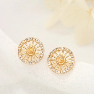 Macro view of 14k gold-plated leaf wheel earring studs with sparkling zircon stones