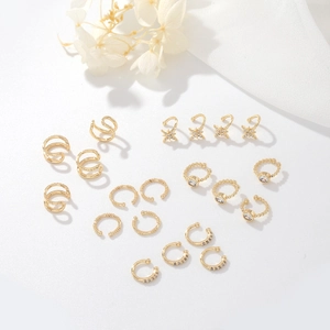 Elegant gold-tone ear cuff set with star design and zirconia stones on white fabric