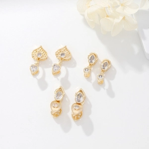 Close-up of gold-plated copper charms with sparkling zircon stones for jewelry making