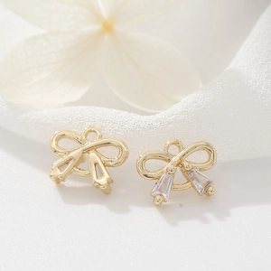 Foto macro de colgantes de lazo dorado con circonita baguette para joyería DIY