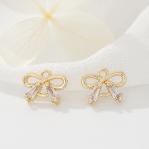 Macro shot of 14k gold-plated bow charm with trapezoid zircon stones for jewelry DIY