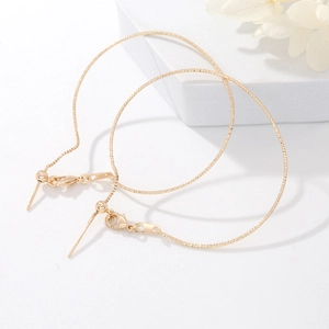 Textured 14K gold plated chain bracelets displayed on white geometric props with dried flowers