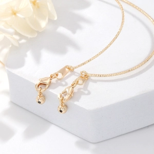 Macro view of 14K gold plated chain bracelets featuring lobster clasps and ball pendants