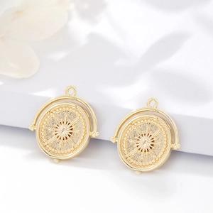 Détail d'un pendentif soleil plaqué or 14K avec cadre rotatif et incrustation zircon