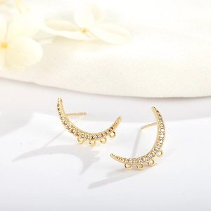 Vue détaillée des boucles d'oreilles croissant dorées avec zircons et trois anneaux