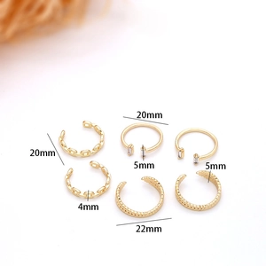 Macro detail of six gold leaf-shaped open rings with chain and crystal patterns