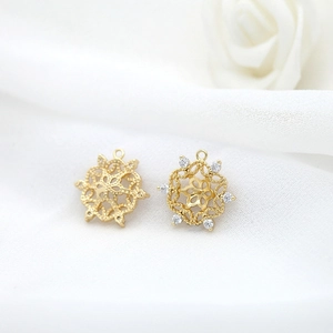 Detailed view of gold plated daisy charm with white zircon inlays and delicate filigree work