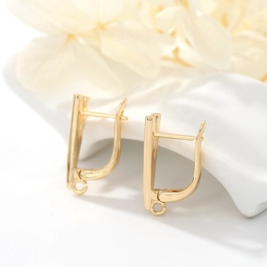 14K gold plated earring hoops with small hanging loops on a white ceramic base