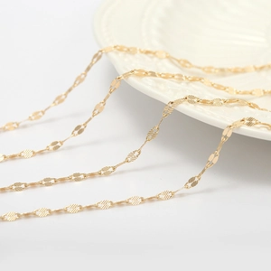 Macro shot of 14K gold plated copper lip chain links with delicate engraved texture