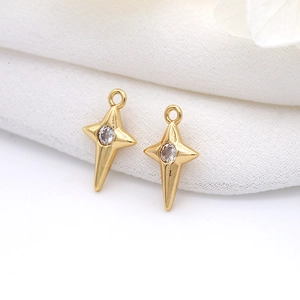 Macro detail of gold four-pointed star charms with micro-pave cubic zirconia inlay