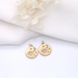 Detail of 14K gold plated celestial pendants with micro-pave cubic zirconia on fabric