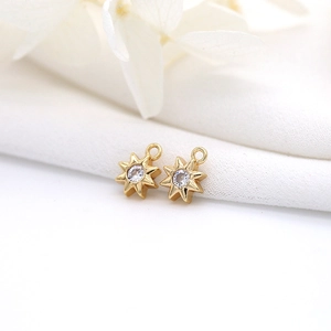 Golden octagonal star pendants with inlaid zircon on white fabric and flower petals