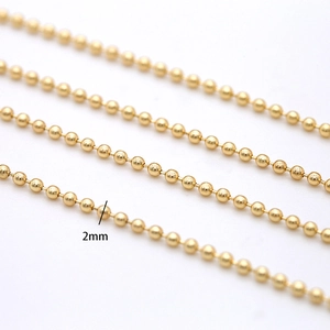 Macro view of 2mm 14K gold plated ball chain showing polished metallic texture and finish