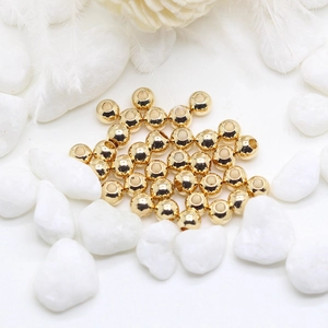 Macro shot of 14K gold plated smooth copper beads with high-gloss finish for DIY jewelry