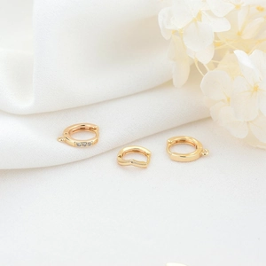 Detailed macro view of 14K gold plated hoop earring findings with cubic zirconia and textures