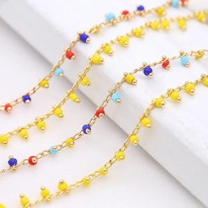 Macro shot of 1.6mm copper chain with heart links and colorful enamel beads for DIY jewelry