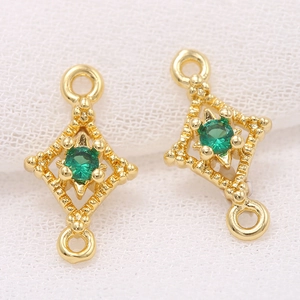Detail of 14k gold plated rhombus connector with green zircon and textured relief finish