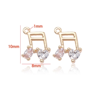 Detail of 14K gold-plated musical note charms with heart and oval cubic zirconia stones