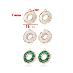 Detail view of 13mm round 14k gold plated pendants with shell and malachite textures