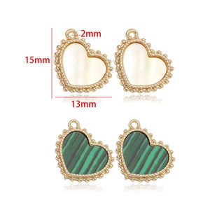 Macro shot of 15mm heart-shaped jewelry pendants with shell inlay and golden beaded edges