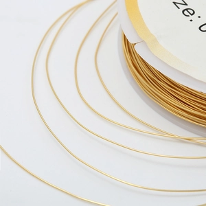 Détail du fil de cuivre doré sur bobine blanche pour la création de bijoux DIY