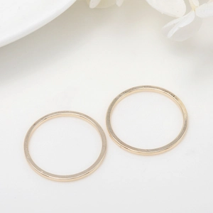 Minimalist gold brass split rings for DIY jewelry making on white elegant background
