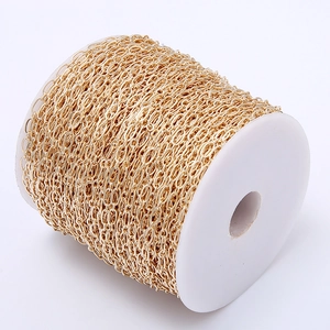 Close-up of gold oval link chain roll for DIY jewelry making on white spool