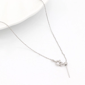 Macro detail of 14k gold-filled adjustable needle chain necklace with stopper bead