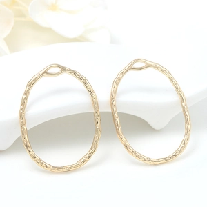 DIY gold oval jewelry pendants with hammered texture on a minimalist white display