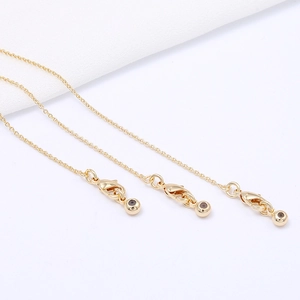 Detailed view of three polished 14k gold-filled necklaces with lobster clasps and gold beads