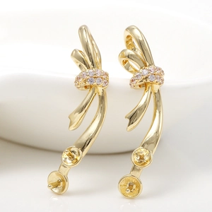 Macro view of 14k gold plated bow earring settings with pink zircon and pearl pins