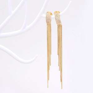 Macro shot of 14k gold-plated long tassel earrings with sparkling zircon inlay details