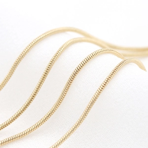 Polished 14k gold-plated snake chain for jewelry making with smooth metallic texture