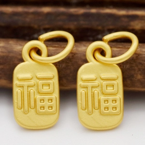 Vue macro de pendentifs Lu en or mat avec caractère Fu gravé pour création bijoux