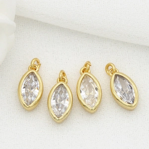 Macro view of four marquise cut zirconia charms with gold plated frames and top loops