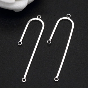 Close-up of silver U-shaped metal jewelry connectors with three rings for DIY crafting