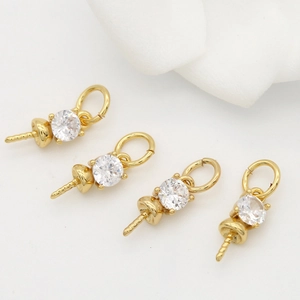 Macro detail of four gold plated brass coin pendants with sparkling zircon stones for DIY jewelry