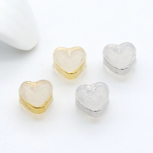 Handmade heart-shaped jewelry accessories in gold and silver metal frames on white background