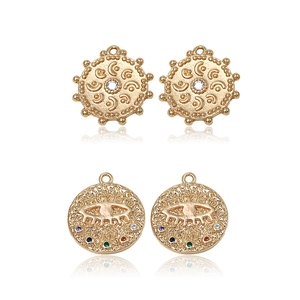 Gold celestial sun and evil eye pendants with colorful zircon inlays and relief details