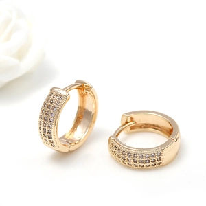 Classic golden huggie hoop earrings with three rows of sparkling zircon stones on white base