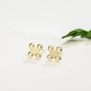 Vue macro des pendentifs en croix à quatre trous plaqués or 14K pour bijoux DIY