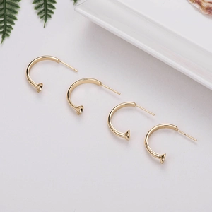 Detailed close-up of four 14K gold-plated C-shaped earring hooks for DIY jewelry making