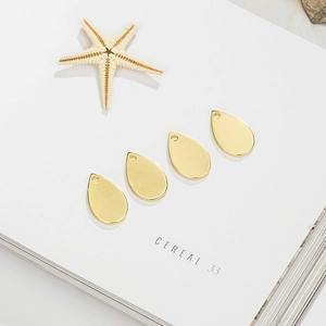 Macro-opname van vier gouden druppelvormige 14K koperen bedels voor DIY-sieraden maken