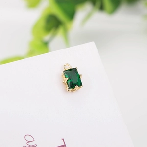 Macro shot of rectangular emerald green zircon pendant with gold plated metal border