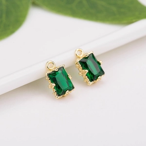 Macro detail of emerald cut green zircon pendants with gold plated hardware for DIY jewelry