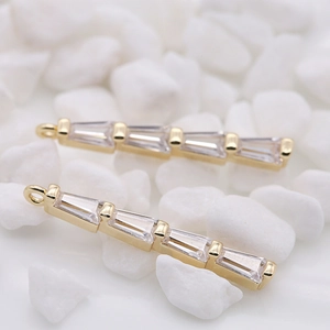 Pendentifs longs en or 14k avec zircons pour bijoux DIY sur fond de galets blancs