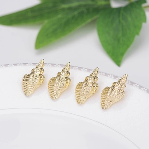 14k vergulde schelphangers voor DIY sieraden maken op een wit keramisch bord