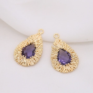Detail of two purple teardrop pendants with textured gold frames for DIY jewelry