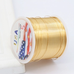 Golden DIY copper jewelry wire on a white spool with long lasting color retention