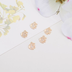 Macro detail of 14k gold-plated fish pendant with white zircon for DIY jewelry making